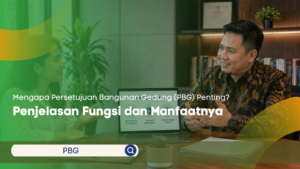 Seseorang sedang mencatat di buku sambil melihat data verifikasi bangunan pada layar laptop di meja kerja kayu